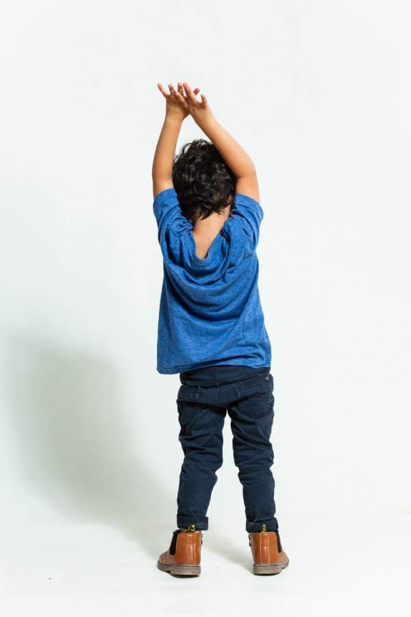 ילד עם מכנסי גינס כהים וחולצה כחולה