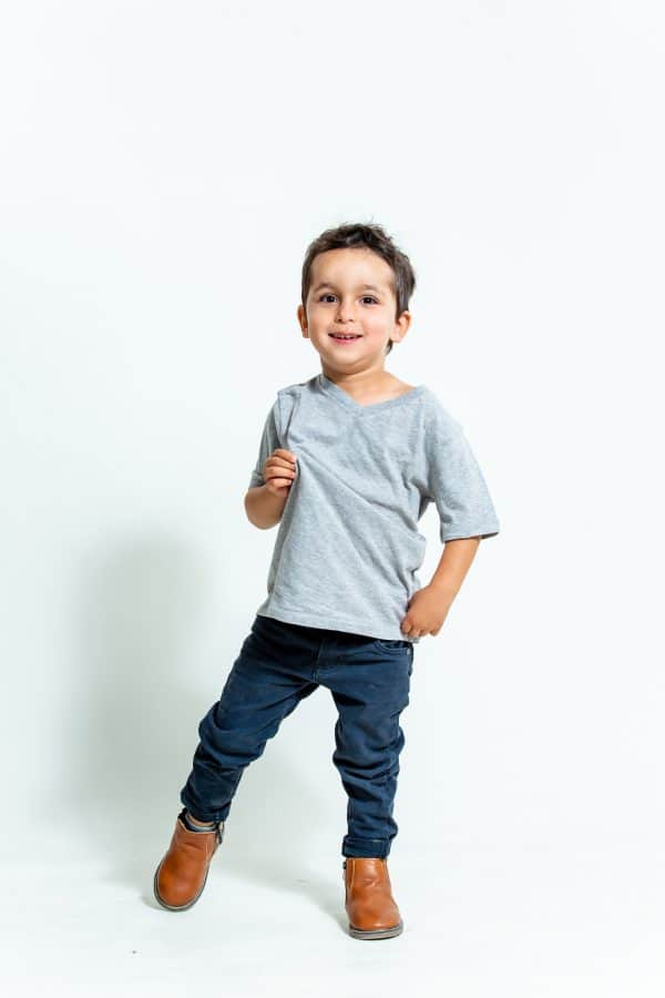 ילד עם מכנסי גינס כהים וחולצה אפורה