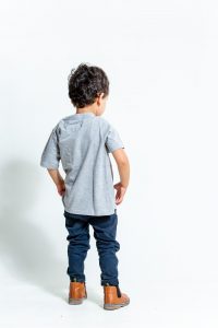 ילד עם מכנסי גינס כהים וחולצה אפורה