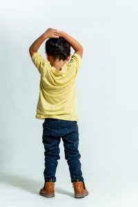 ילד עם מכנסי גינס כהים וחולצה צהובה